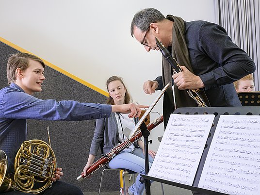 Unterrichtssituation Kammermusik mit zwei Studierenden und einem Professor.