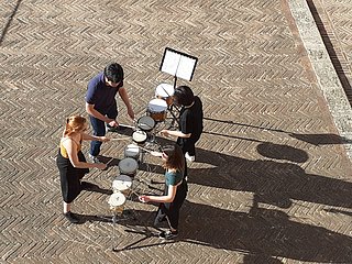 Vier Studierende bei einer Perkussion-Probe im Innenhof des Palazzo Ricci