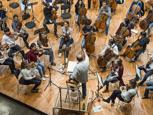 Orchester auf der Bühne mit Dirigent.