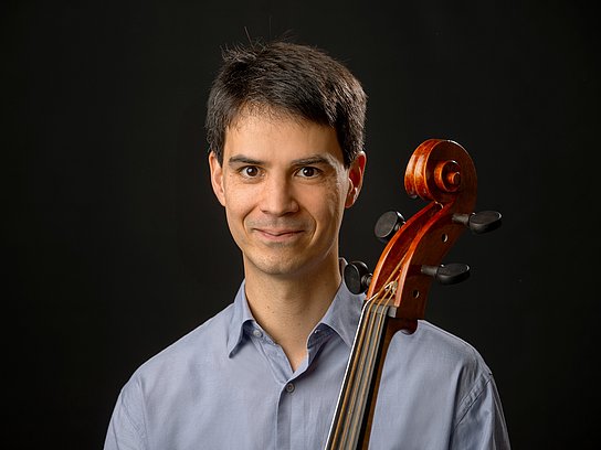 Es ist eine männliche Person im Portraitmodus zu sehen. Vor seiner Brust ist der Steg einer Viola da Gamba zu sehen.