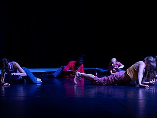 Personengruppe die sich umarmen und unscharfe, tanzende Person