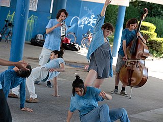 Musiker*innen und Tänzer*innen bei einer Performance am Rhein