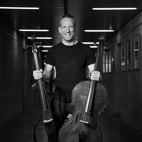 Person hält ein Violoncello in der Hand