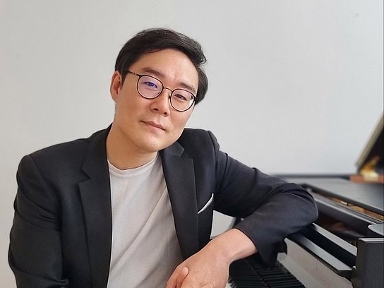 Jeongro Park sitzt an einem Klavier