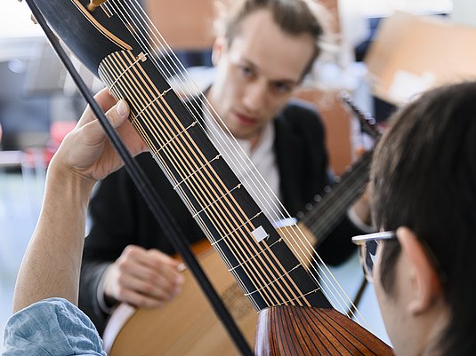 Unterrichtssituation mit einem Studierenden und Professor mit dem Instrument Laute.