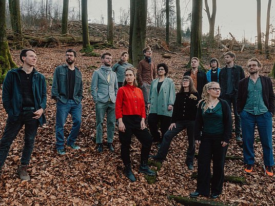 Personen stehen im Wald