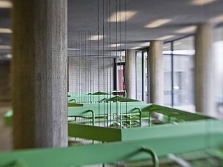 Ausschnitt aus dem Zwischengeschoss mit grünem Geländer