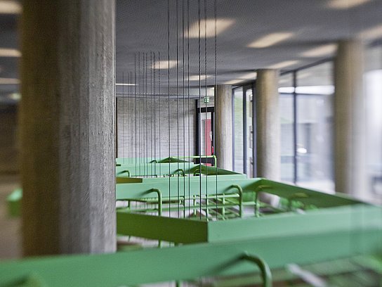 Ausschnitt aus dem Zwischengeschoss mit grünem Geländer