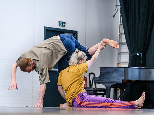 Zwei Tänzer*innen proben im Tanzsaal.