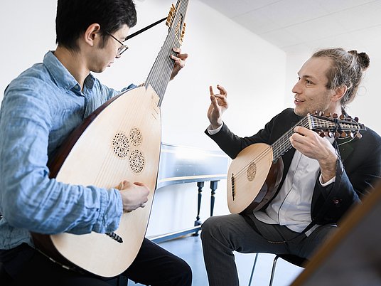Unterrichtssituation mit einem Studierenden und Professor mit dem Instrument Laute.
