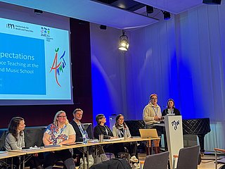 Podiumssituation mit Personen auf der Bühne