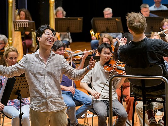 Singende Person, Dirigent und Orchester