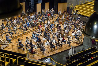 Orchester auf der Bühne mit Dirigent.