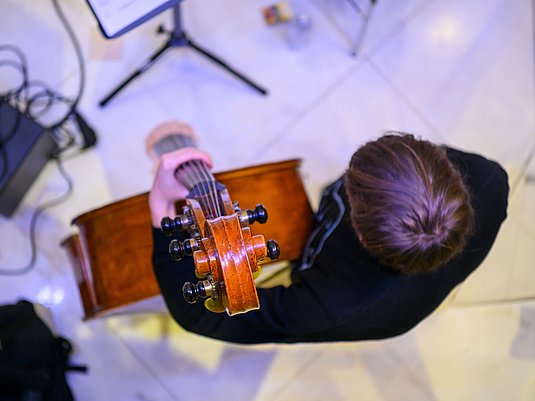 Studiernder mit einem Kontrabass von oben fotografiert.