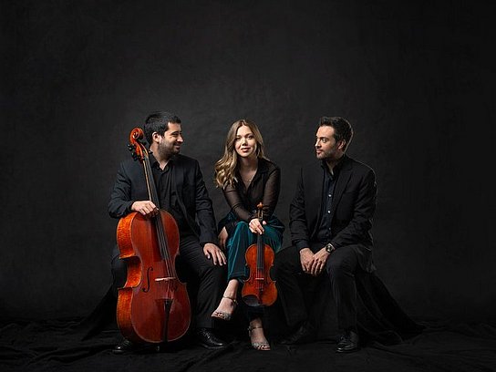 Drei Personen mit einem Violoncello und Violine