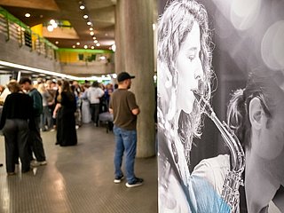 Personen stehen im Foyer und rechts ein Ausschnitt eines Kundenstoppers mit Klarinette