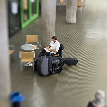 Foyer am Standort Köln mit einem sitzenden Studierenden