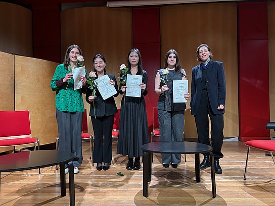 Stipendien der Gleichstellung | Blechbläserinnen Fünf Personen auf der Bühne, vier halten Urkunde in der Hand