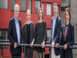 Fünf Personen (Kanzler*in, Prorektor*in und Rektor*in) des Rektorats stehen im Innenhof der HfMT