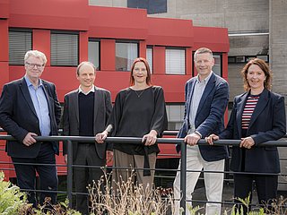 Fünf Personen (Kanzler*in, Prorektor*in und Rektor*in) des Rektorats stehen im Innenhof der HfMT