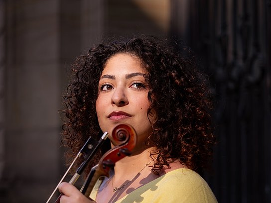 Sitzende Person mit einer Violine in der Hand