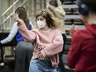 Tanzende Personen mit Kopfhörer und Mundschutz