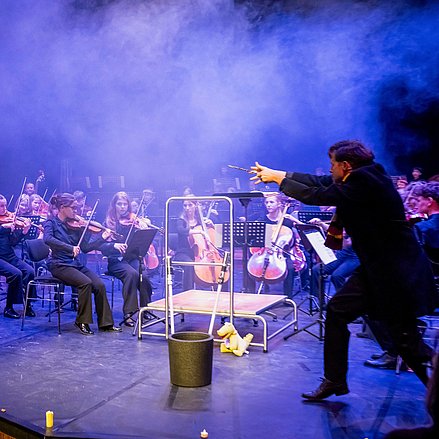 Orchester mit einem Zauberer auf der Bühne