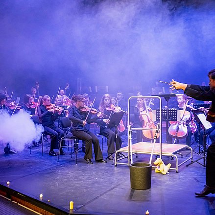 Orchester mit einem Zauberer auf der Bühne
