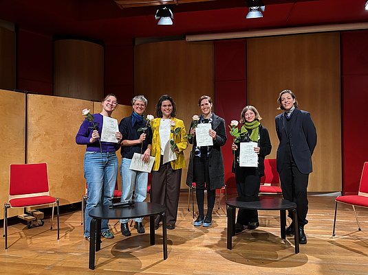 Stipendien der Gleichstellung | Genderthematik Sechs Personen auf der Bühne, fünf halten Urkunde in der Hand