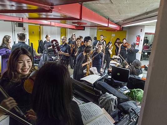 Gruppe internationaler Studierenden mit Instrumenten.