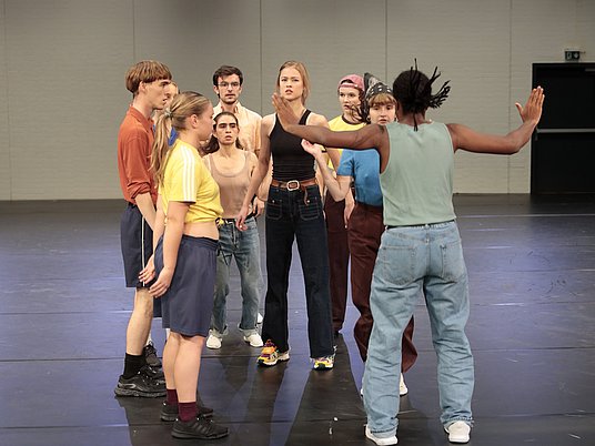 Unterrichtssituation Tanz mit einer Gruppe Studierender auf der Bühne.