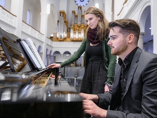 Unterrichtssituation Klavier mit zwei Studierenden.