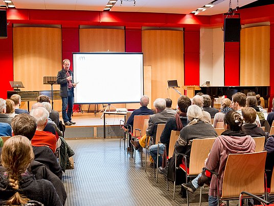 Referent hält ein Vortrag vor Publikum im Kammermusiksaal