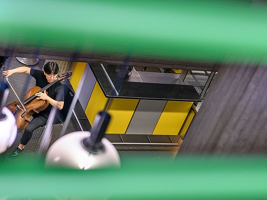 Cellist*in im Foyer der Hochschule am Standort Köln