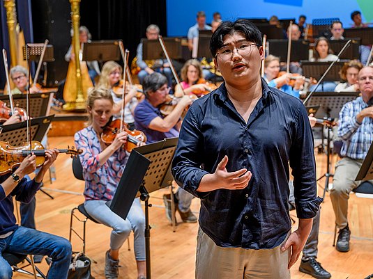 Singende Person mit Orchester